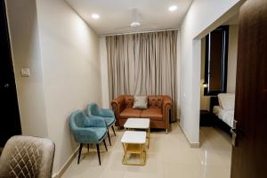 a living room with a couch and chairs and a bed at The Core in Kohīma +7 photos