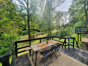 a wooden deck with a table and chairs on it at Promenade dans la Vallée de la Meuse in Blaimont