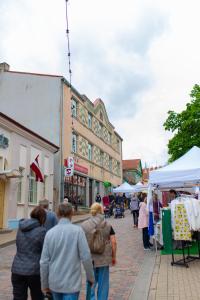 a group of people walking through a street market at Talsu Vecpilsētas apartmenti in Talsi +5 photos