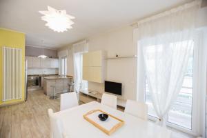 a living room with a white table and white chairs at Ampio appartamento in centro Pescaramare in Pescara