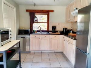 a kitchen with white cabinets and a stainless steel refrigerator at Promenade dans la Vallée de la Meuse in Blaimont