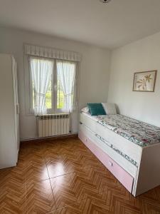 a bedroom with a large bed and a wooden floor at 3Raigaños Vivienda Vacacional in Sales