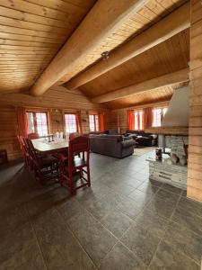 Una sala de estar con una mesa y sillas y un sofá. en Lomtjern, en Beitostølen 3 fotos más