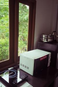a microwave sitting on a table next to a window at The Canal Hut Chaloklum in Chaloklum
