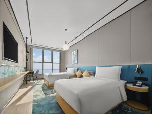a hotel room with a large bed and a couch at Hilton Garden Inn Danzhou Yangpu in Danzhou +27 photos