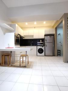 a kitchen with white appliances and a white tile floor at Seri Bukit Ceylon in Kuala Lumpur