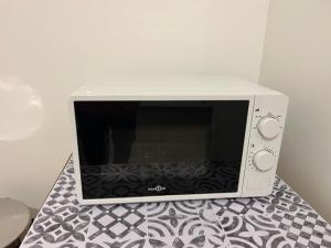 a microwave oven sitting on a counter with a table at La ferme 