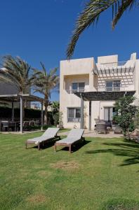 een gebouw met banken in het gras ervoor bij VESTA - Gouna Residence in Hurghada