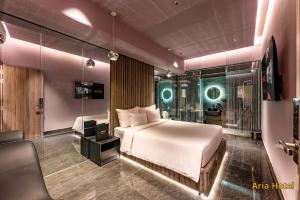 a bedroom with a bed and a tv and a couch at Oria Hotel Gò Vấp in Ho Chi Minh City