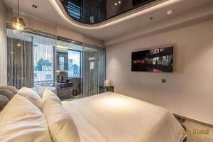 a bedroom with a large bed and a tv at Oria Hotel Gò Vấp in Ho Chi Minh City
