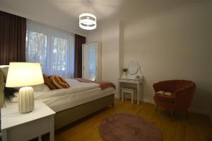 Un dormitorio con una cama, una mesa y una silla. en Apartamenty Marina na Wydmie, en Mrzeżyno