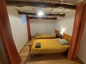 1 Schlafzimmer mit 2 Betten in einem Zimmer mit einer Decke in der Unterkunft Au petit hameau Cabrespine in Cabrespine + 2 Fotos