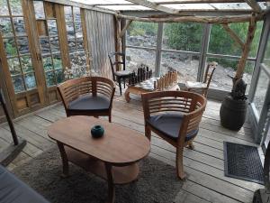 a porch with chairs and a table on a wooden deck at Chalet Banassac in Saint-Ambroix +41 photos