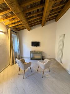 a living room with two chairs and a tv at La Dimora Di Roberta in Montalcino