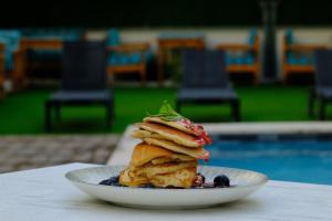 a stack of pancakes on a plate next to a pool at Sorta Hotel in Antalya