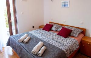 a bedroom with a bed with four pillows on it at Melone Apartman 3 Senj by Villas Guide in Sveti Juraj