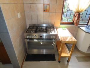 a stove in a small kitchen with a wooden table at High Tide & Green Grass in Hibberdene