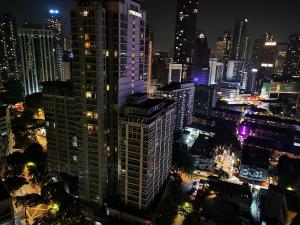 a city skyline at night with a tall building at Seri Bukit Ceylon in Kuala Lumpur