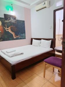 a bedroom with a bed and a purple stool at Khách Sạn Bảo Long in Ho Chi Minh City