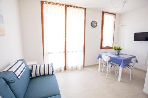 een woonkamer met een blauwe bank en een tafel bij Appartamento Lo Scoglietto in Portoferraio