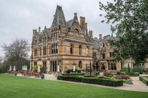 an old mansion with a lawn in front of it at Ettington Park Hotel, Stratford-upon-Avon in Stratford-upon-Avon