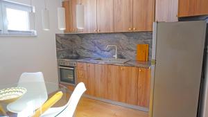 a kitchen with a table and a sink and a refrigerator at Apartment Sara in Mostar