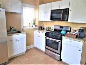 a kitchen with white cabinets and a stove top oven at Delightful Private Room in Washington DC in Washington, D.C.
