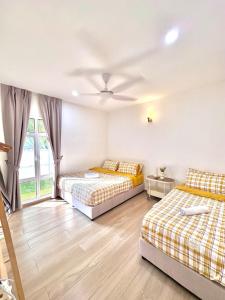 a bedroom with two beds and a window at Afamosa Sunset Villa 22pax Snooker BBQ KTV New in Kampong Ulu Pegoh