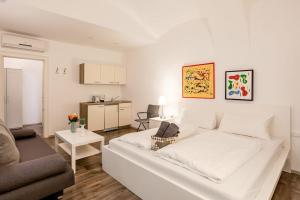 a living room with a white bed and a couch at Beautiful Apartment 3 City Center in Vienna