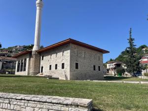 a large stone building with a tall tower on top at Apartment Koka in Berat