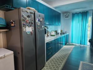 una cucina con armadi blu e frigorifero in acciaio inossidabile di Family Home near Cyberjaya a Puchong