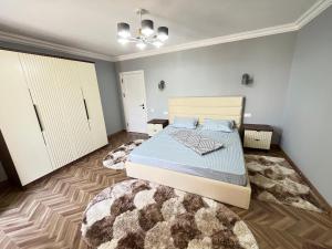 a bedroom with a bed and a rug at Apartment lux in Samarkand