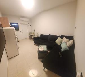 a living room with a black couch and a table at יחידת נופש ריף in Eilat