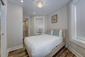 a white bedroom with a bed and a window at Suite C - Dupont Circlekalorama Luxury Apartment in Washington