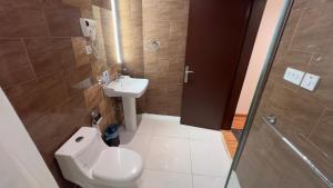 un bagno con wc, lavandino e doccia di فندق راحة السلام a Buraydah