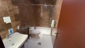 un bagno con doccia, WC e lavandino di فندق راحة السلام a Buraydah 1 altra foto