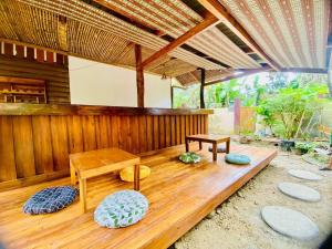 a wooden porch with a table and benches at Forest wood-Port Barton in San Vicente