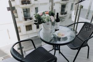 a table with a bottle of wine and flowers on a balcony at SeaLine Apart-Hotel in Odesa