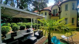 a patio with couches and a table in front of a house at Villa Justyna in Pobierowo