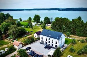 an aerial view of a white house with a parking lot at Flauta Apartamenty in Augustów