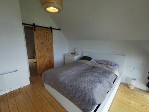 a bedroom with a bed and a wooden floor at GrudKa, domek w górach in Grudza