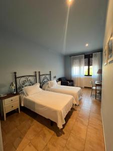 Un dormitorio con dos camas y una sala de estar. en Novella Hotel de Muntanya, en Benasal