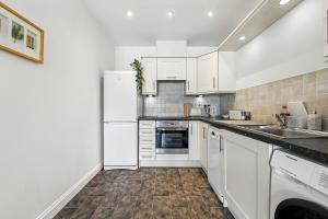 Una cocina con un refrigerador blanco y un fregadero. en Two Bedroom Flat by Brookland Stays Serviced Accommodation Short Lets Leeds with Free WiFi, en Leeds 7 fotos más