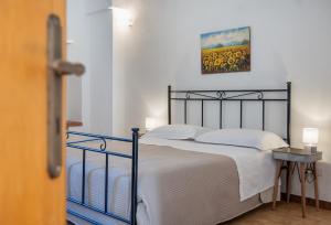 a bedroom with a bed with a painting on the wall at B&B Masseria Donna Carlotta in Serrano