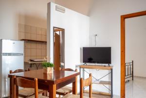 a kitchen and dining room with a table and a refrigerator at B&B Masseria Donna Carlotta in Serrano