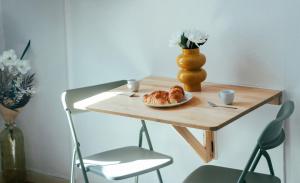 a table with a plate of croissants and a vase at Le petit coin vert de Paris in Montreuil +12 photos