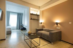 una sala de estar con un sofá y una mesa en Belle Athenes Apartements, en Atenas