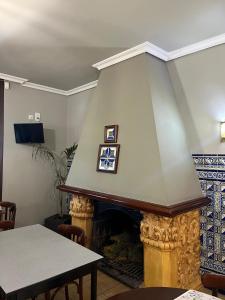 Una sala de estar con chimenea con dos cuadros en ella. en Novella Hotel de Muntanya, en Benasal