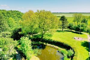 an aerial view of a park with a pond and trees at Cozy Wohnung fuer 4 Gaeste mit Terrasse unter Reet in Sankt Peter-Ording +30 photos