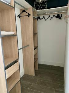 a walk in closet with wooden doors and tile floors at T2 moderne et lumineux, clim, terrasse et vue mer in Bastia